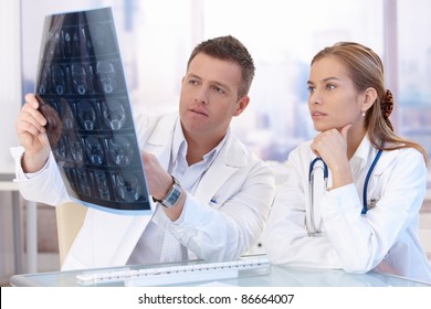 Two Doctors Studying X-ray Image, Consulting In Bright Office.?