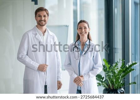 Two doctors talking in the clinics corridor and looking contended