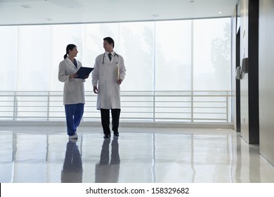 Two Doctors Walking And Smiling In The Hospital