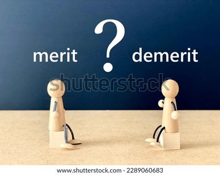 Two dolls _merit and demerit characters sitting on a cube facing each other