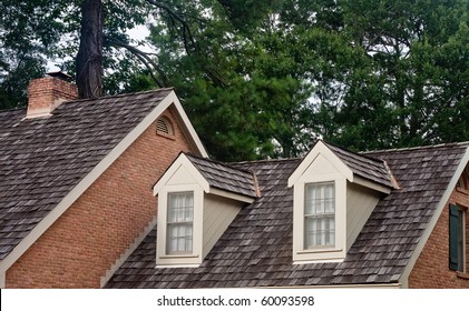 Two dormers on the roof of a wood shingled home