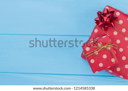 Two dotted red gift boxes. Copyspace. Blue wood background.