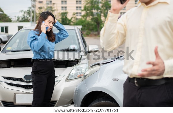 Two drivers call insurance after a car accident
before taking pictures and sending insurance. Online car accident
insurance claim idea after submitting photos and evidence to an
insurance company.
