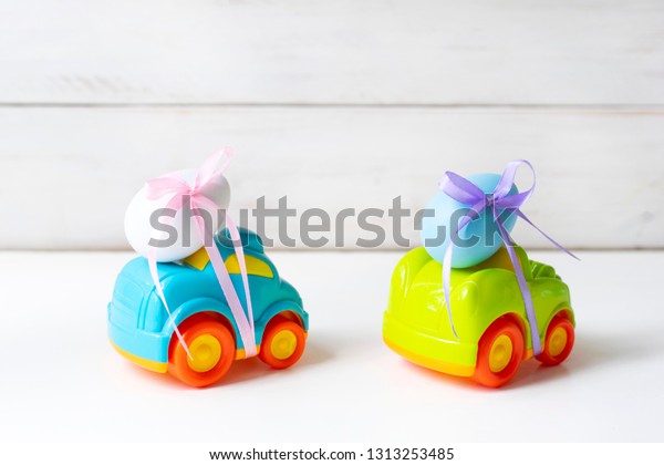 Two easter cars with an egg on a white\
background, the concept of the approaching\
easter