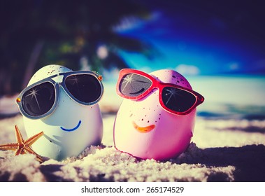 Two easter eggs with sunglasses on ocean beach  - Powered by Shutterstock