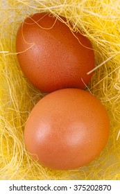 Two eggs on a yellow texture in the form of hay