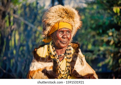 Two elder woman from southern Africa dressed in a traditional costume with a hat and cow hide in a village in the rural area - Powered by Shutterstock