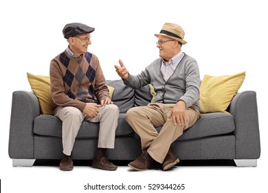 Two Elderly Men Sitting On A Sofa And Talking Isolated On White Background