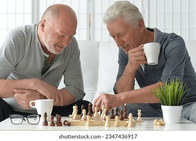 two elderly senior men playing chess at home - Powered by Shutterstock