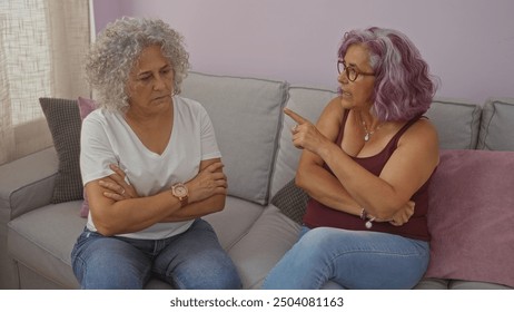 Two elderly women with curly hair having a serious discussion in a cozy living room - Powered by Shutterstock