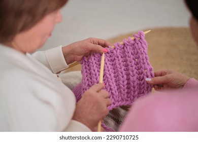 Two elderly women share a special moment, as one shows the other a beautiful knitted scarf she has made. touching display of the deep bonds of friendship and joy of sharing our passions with others - Powered by Shutterstock