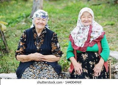 Two elderly women sitting outdoors