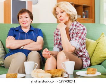 Two Elderly Women Sitting At The Table With Tea And Sharing Bad News