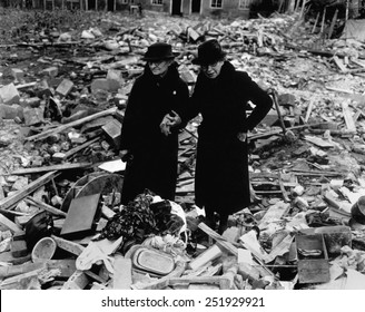 Two elderly women stand amid the ruins of the Almshouse that had been their home. The Germans bomber Newbury, Berkshire, England on Feb. 10, 1943. World War 2. 10_59)