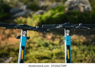 Two electric scooters stand side by side against a natural background - Powered by Shutterstock