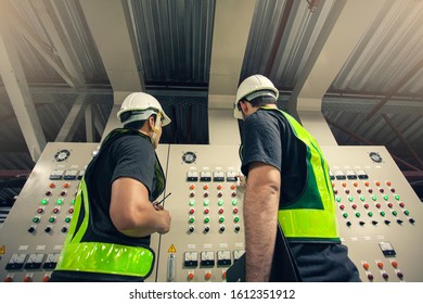 Two Electrical Engineer team working front control panel, Engineer training job with control panel in service room.