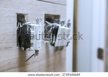 Two electrical outlets are open with wires exposed in home, showing ongoing repair work