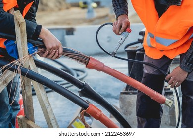 Two electrician builder workers installing high-voltage cable