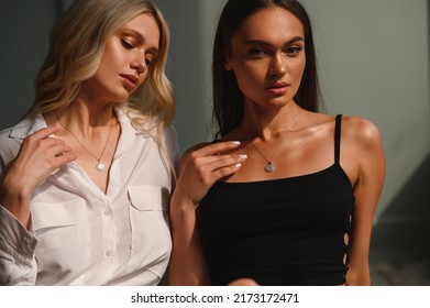 Two elegant, beautiful, young girls with jewelry around their necks. Portrait