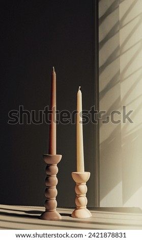 Two elegant bubble taper candle holders with taper candles in side blind lights on dark background. Interior design.