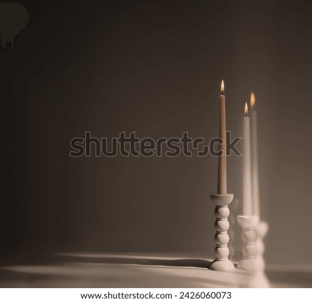 Two elegant bubble taper candle holders with burning taper candles on a dark background. Interior design.