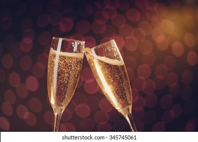 Two elegant champagne glasses making toast on holiday bokeh background  