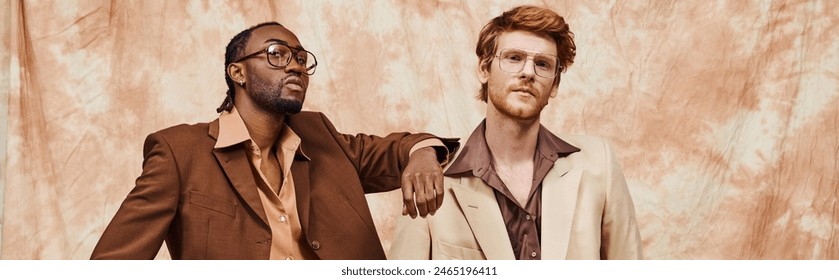Two elegant, multicultural men exude confidence in dapper attire, standing side by side.