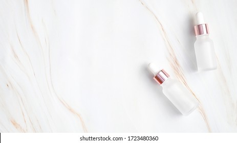 Two Elegant Transparent Dropper Bottles For Essential Oil On Marble Background. Luxury Cosmetic Containers Mockup, Stylish Packaging Design