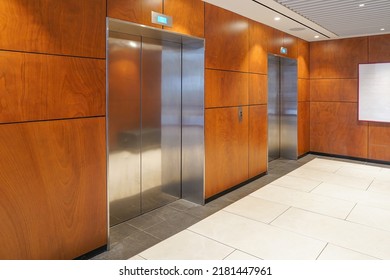 Two Elevator Doors In Office Building. Wide Angle View Of Modern Wood Elevators With Doors. Elevators In The Modern Wood Lobby House Or Hotel. Two Elevator Doors In Building