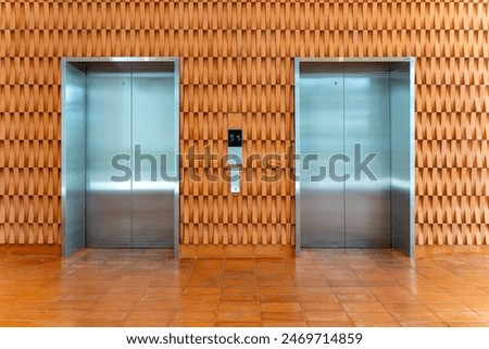 Two elevators with beautiful model design wall in office building, Blank space on closed doors for insert your advertising, indoors poster, public Announcement in building or shopping mall