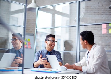 Two Employees Discussing Data At Workplace In Office