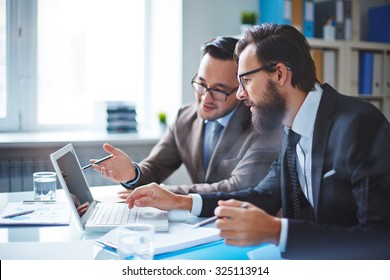 Two Employees Discussing Electronic Data At Meeting