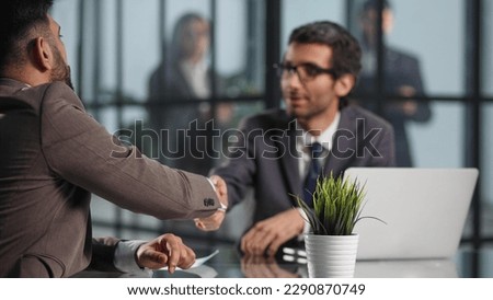 Two employees in a modern officeworking at a table, colleagues discussing and consulting,