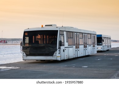 Two Empty Airport Shuttle Buses In A Cold Winter Evening