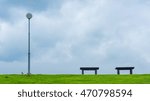 Two empty benches along a path in a public park

