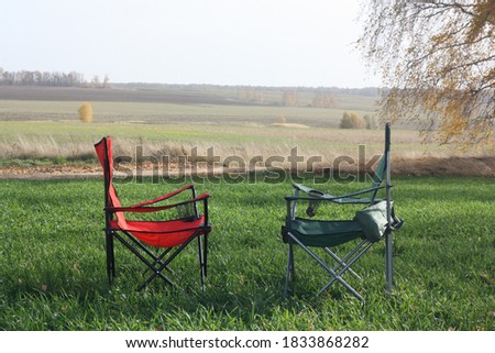 Two empty camping chairs stand in a field. Actice Relaxation Lifestyle