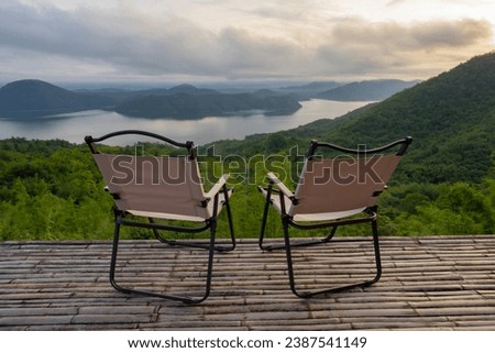 Two Empty Camping Chairs Standing on the Top of the Mount. Perfect Place for Watching Sunset. Actice Relaxation Lifestyle, Tourist tent in camp among with mountain view on sunrise, Travel vacation.