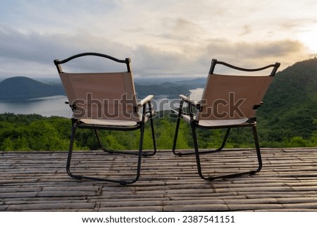 Two Empty Camping Chairs Standing on the Top of the Mount. Perfect Place for Watching Sunset. Actice Relaxation Lifestyle, Tourist tent in camp among with mountain view on sunrise, Travel vacation.