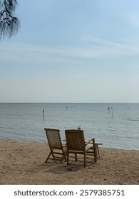 Two empty chairs..facing the sea and decorated with a very beautiful afternoon sunlight