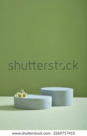 Two empty podiums decorated on minimalist light background with some Feverfew flowers (Tanacetum parthenium) placed on it. Empty space for product advertising
