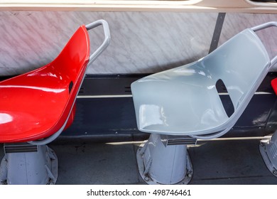 two empty red and grey seats in an old tram at the window
