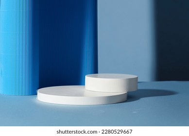Two empty round white platforms stacked on top of each other, decorated on blue background. Empty space for display product, text and design. - Shutterstock ID 2280529667