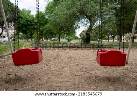 Two empty swings, lonely lovers, kindergarten, red swings in park,