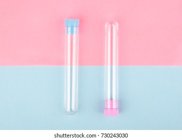 Two empty test tubes on a pink and blue paper background (minimal concept, top view)