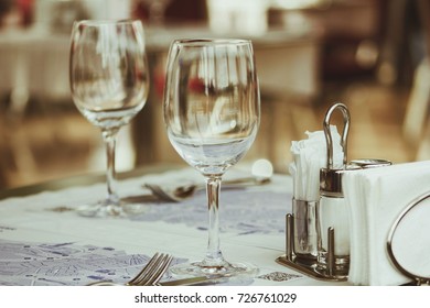 Two empty transparent wine glasses stand at table in small Japanese restaurant.