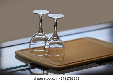 Two empty wine glasses on dining table, selective focus.