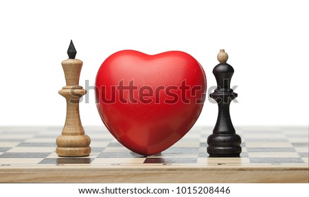 Two enemies fall in love. There is the red heart between white chess queen and black king on the chess board. Isolated. Forbidden love. 