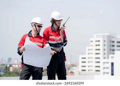 Two engineer checking solar energy system looking blueprint for planning installation solar panel together while speak on walkie talkie, renewable energy sustainable, industry and solar cell.