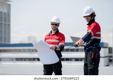 Two engineer checking solar energy system looking blueprint together for planning installation solar panel, renewable energy and sustainable technology, clean electricity, industry and solar cell.