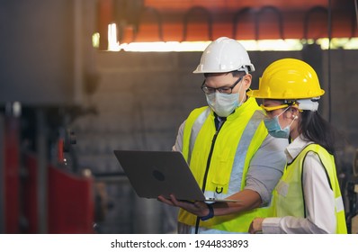 Two engineer in hard hat wearing safety using laptop for planning a project. Foreman explaining machinery to female employee - Shutterstock ID 1944833893
